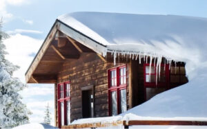 Mountain cabin with heavy snow and ice on roof